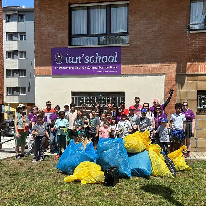 Academia de inglés en Gijón con profesores nativos y alumnos felices tras actividad de recogida de basura en los Pericones